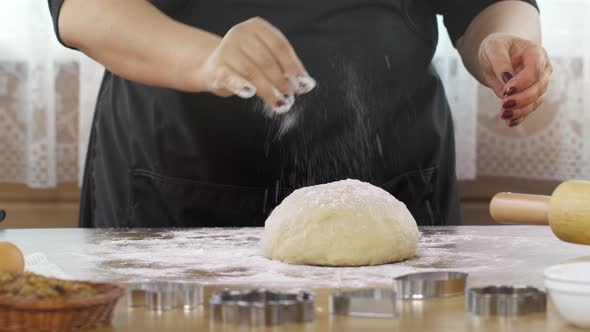 Women's Hands Sprinkles Dough with Flour Cuts with Knife Baking Pastry at Home