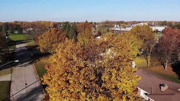 A rising autumn aerial establishing shot of a typical middle-class Michigan residential neighborhood