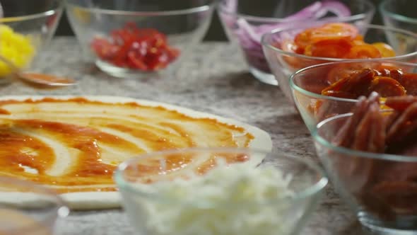 Spreading Ketchup on Pizza Dough