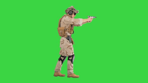 Special Operations Training Soldier Walking and Shooting From Hand Gun on a Green Screen, Chroma Key