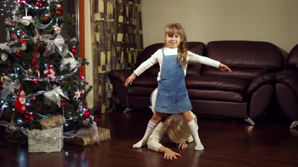 Mother and daughter having fun near Christmas tree