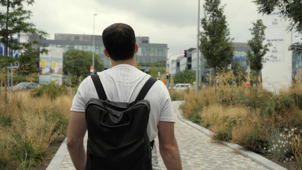 Adult Caucasian Man with Backpack Walking on Street In