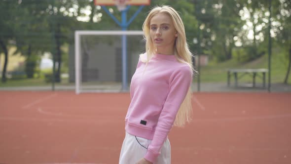 Blond Slim Woman Turning To Camera and Smiling. Portrait of Happy Young Caucasian Sportswoman Posing