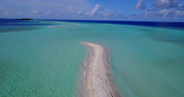 Wide angle drone travel shot of a white sand paradise beach and blue water background in colorful 