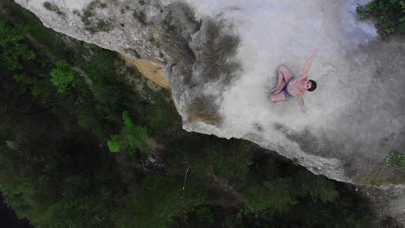 Young Shirtless Man Meditating on the Edge of a Mountain Around the Forest in Early Morning