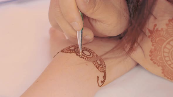 Closeup Shot of Mehendi Henna Tattoo Application Process on Female's Hand