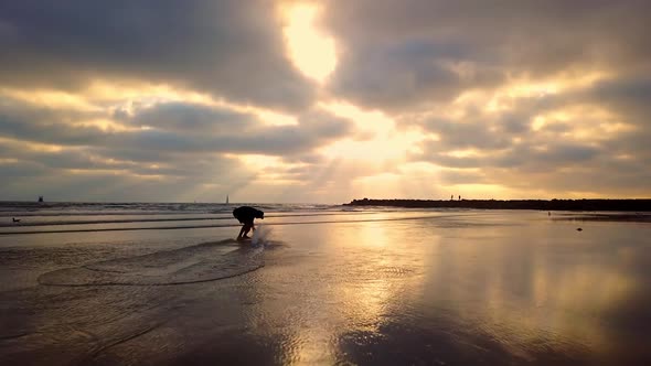 Man spinning in circles on skimboard at colorful beach