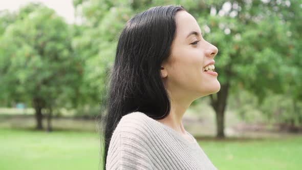 Side View Portrait of a Young Woman Breathing Fresh Air Relaxing in the Park