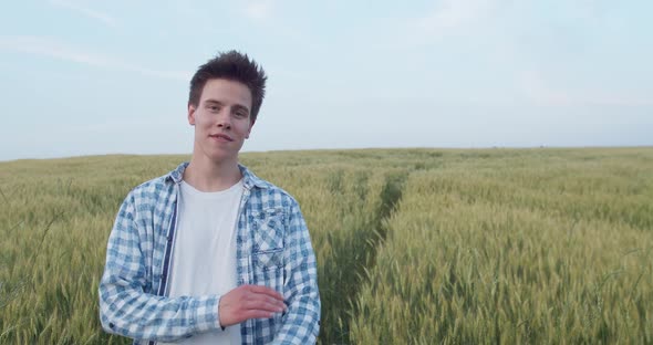 Portrait of Boy Talking and Crossing Hands with Smile at Camera in Wheat Field