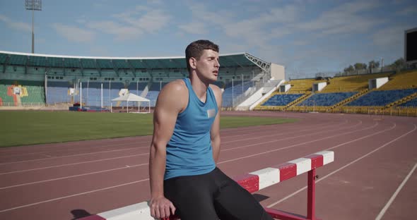 Sweaty Sportsman Resting Near Hurdle