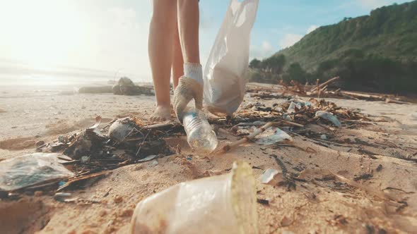 Barefoot Woman Collects Plastic Trash with Beach Putting Garbage in Bag