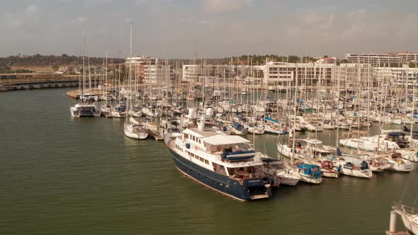 Aerial Drone View of Lagos Pictoresque Seaport Town with Many Sailing Boats Circle Pan Sunny Day