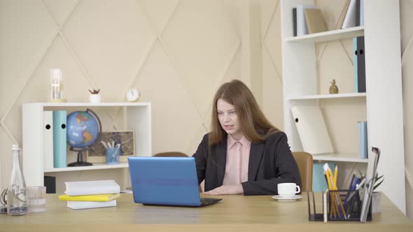 Carefree Caucasian Female Freelancer Standing Up in Sleeping Pants and Closing Laptop