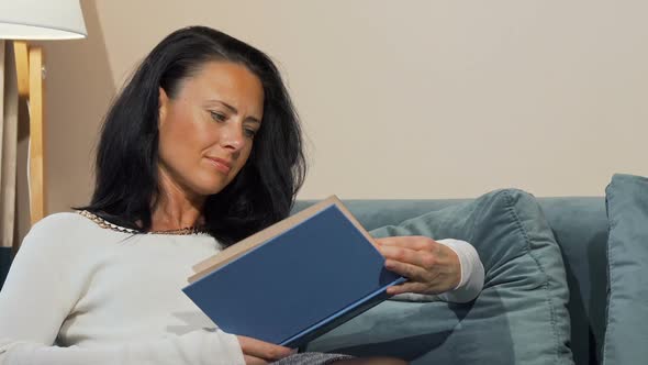 Relaxed Mature Woman Enjoying Reading a Book on the Couch at Home 1080p