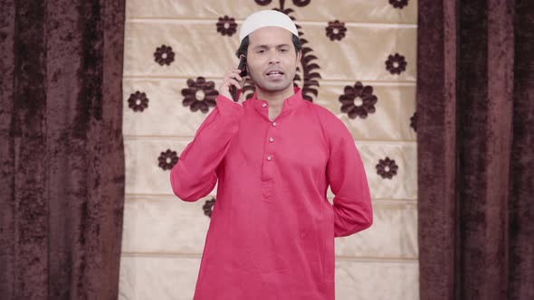 Happy Muslim man talking on mobile phone