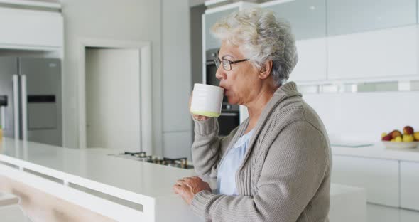 African american senior woman drinking coffee in the kitchen at home