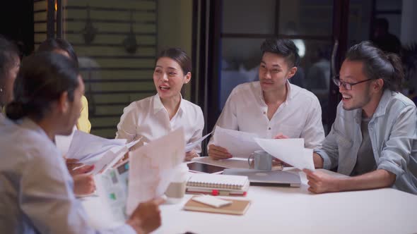 Asian happy business people group have discussion meeting brainstorming on table overtime in office.