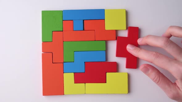 Woman Hand Folds Different Shapes Wooden Blocks to Finish Puzzle