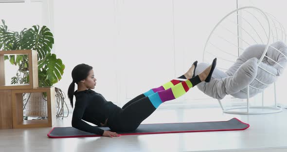 Black woman performing fitness exercises at home.