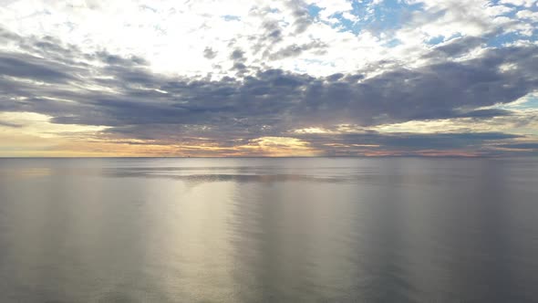 AERIAL: Ascending Pedestal Shot of Horizon and Cumulus Cloudy Sky with Calm Baltic Sea