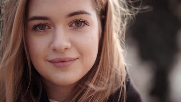 Closeup Portrait of Attractive Female Having Natural Makeup Posing on Camera and Smiling with Wind