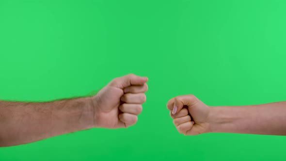 A Woman a Man are Playing Rock Paper Scissors Against the Background of the Green Screen