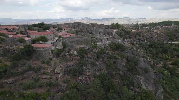 Drone flying toward Sortelha medieval castle and village in Portugal. Aerial pov