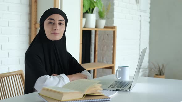 A Female Student in a Hijab is Undergoing Distance Learning