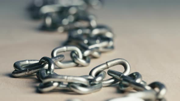 Metal Iron Chain Resting Long on a Wooden Table