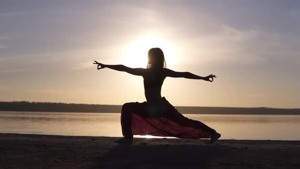 Silhouette of a Slender Girl Do Warrior Namaste Yoga Pose at Sunset