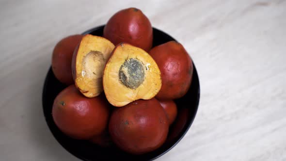 4K top down showing many Chontaduro Fruits in bowl on table,close up - prores