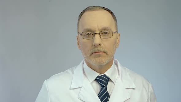 Serious Male Doctor Showing Syringe and Ampoule, Ready to Make Vaccine Injection