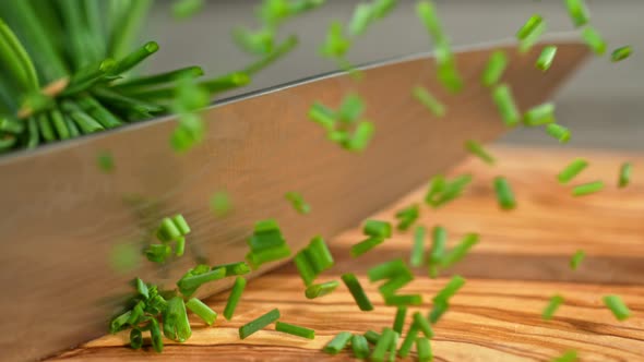 Super Slow Motion Shot of Cutting Chive on Wooden Cutting Board at 1000Fps.