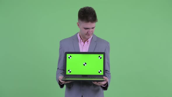 Stressed Young Businessman Showing Laptop