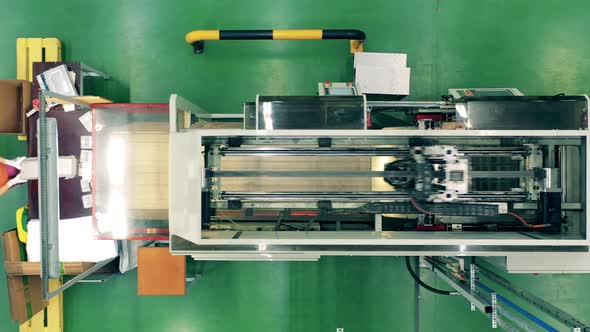 Top View of Wrapping Machine Packing Goods Worker Puts Them To Cardboard Box