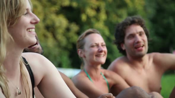 Four friends laughing while sitting in nature