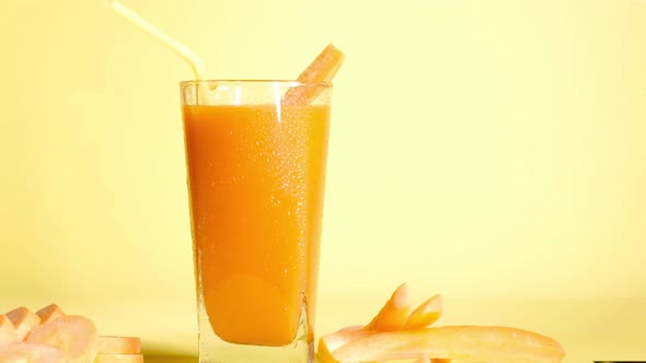 Healthy smoothie carrot juice vegetable cocktail tube on yellow background