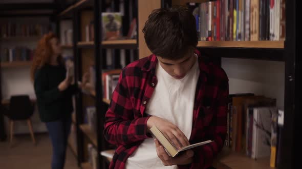 Young Handsome Man Standing Leaning on Reading a Book  Commuter Student Knowledge Concept