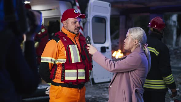 Female Journalist Interviewing Paramedic After Disaster