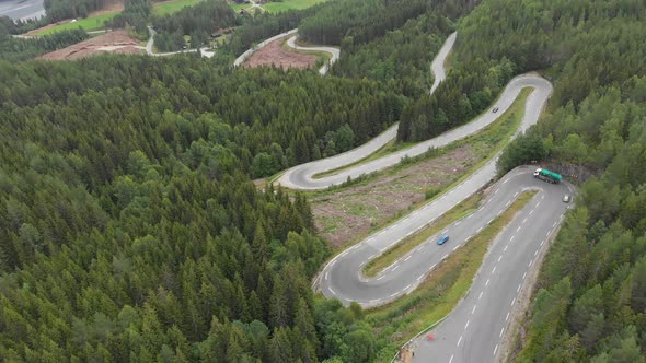 Aerial: vehicles driving on winding mountain hairpin roads
