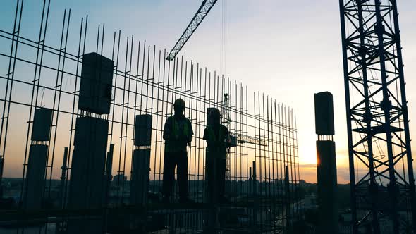 Men Work on a Construction Site on a Sky Background.