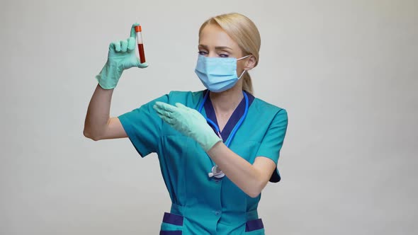 Medical Doctor Nurse Woman Wearing Protective Mask and Latex Gloves - Holding Blood Test Tube