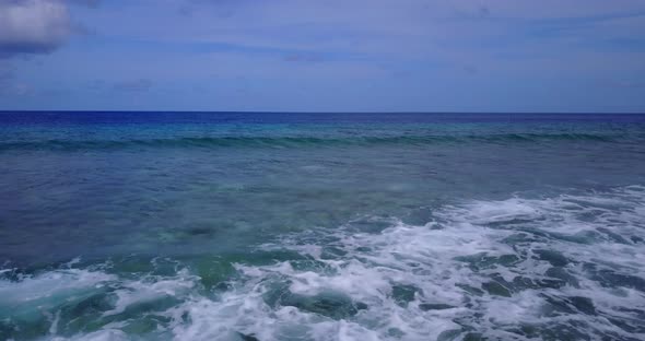 Wide overhead travel shot of a white paradise beach and blue sea background in hi res 4K