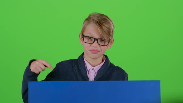 Child Boy in the Glasses Gets Up and Shows on a Board on a Green Screen