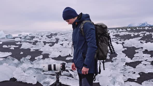 Photographer on Diamond Beach Near Glacier Lagoon of Iceland