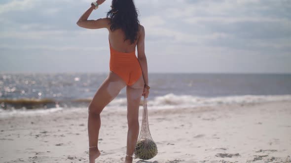 Woman in Swimsuit with Watermelon on the Beach Outdoors