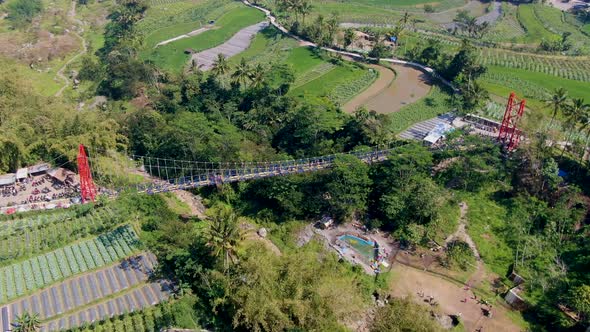 Iconic bridge of Jokowi in Muntilan, surrounded by tropical landscape, aerial drone view