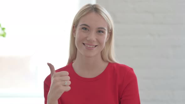 Young Blonde Woman showing Thumbs Up Sign