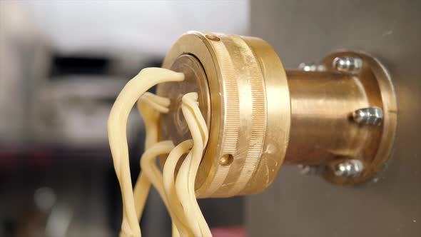 Tortiglioni Cazarece Spaghetti Pasta Falling From a Spout As They Travel Along the Production Line