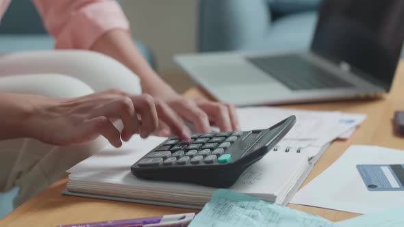 Close Up Of Woman's Hand With The Bill Calculating Money By Calculator